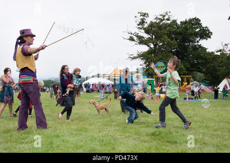 Newport, Wales - 23 Aug 14: Bubblemen am Arbeitsplatz - Mann schafft riesige Blasen für eine Masse von Kindern für Kinder mit Spielen und 14 Aug 2015 Pop an der Gr Stockfoto