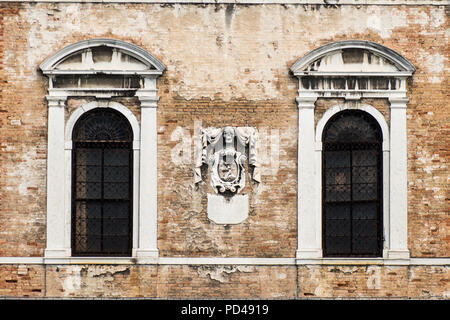 Ein Stein Schädel zwischen zwei Windows auf einem venezianischen Palast Stockfoto