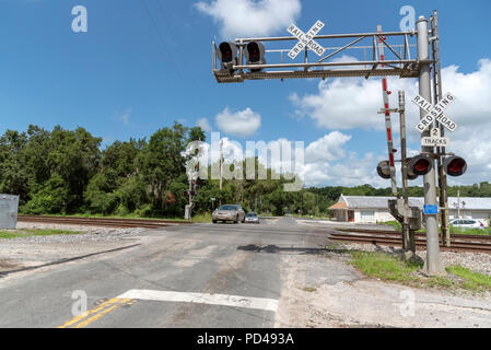 Summerfield, Florida, USA, 2018. Eisenbahn Signale und Anschluss durch North Florida Landschaft. Auto Überqueren der Kreuzung. Stockfoto