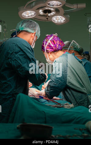 Arzt, Assistant und Krankenschwester bei einem Patienten während einer Hysterektomie Operation in einem Krankenhaus konzentriert Stockfoto