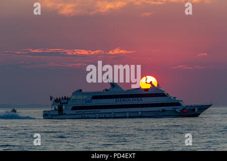 Zadar, Kroatien - 24. Juli 2018: Boot übersetzende Passagiere bei Sonnenuntergang in Zadar Stockfoto