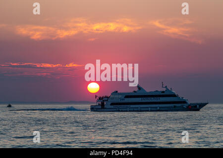 Zadar, Kroatien - 24. Juli 2018: Boot übersetzende Passagiere bei Sonnenuntergang in Zadar Stockfoto