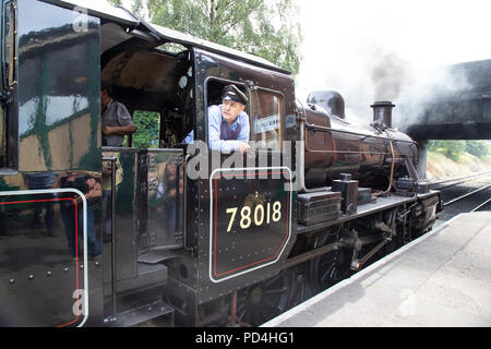 Motor Treiber auf die fußplatte von Nr. 78018 British Railways Standard Klasse 2 Dampflokomotive und aus der Kabine suchen Stockfoto