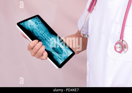 Arzt holding Tablet und x-ray Bild auf dem Bildschirm und Stethoskop halsschleife Stockfoto