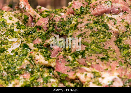 Rohes Fleisch mariniert in Knoblauch Olivenöl Petersilie Salz Pfeffer Stockfoto