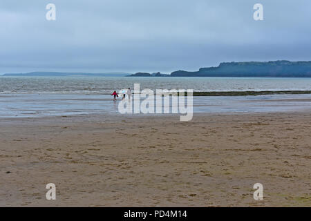 Fernsicht auf die Familie zu Fuß zum Meer am Sandstrand von Amroth Pembrokeshire. Stockfoto