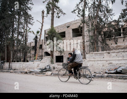 Ein alter Mann und sein Sohn auf dem Fahrrad in der Duma Damaskus Syrien 20-5 2018 Stockfoto
