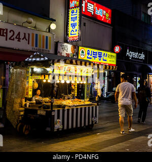 Suwon, Südkorea - 14. Juni 2017: Anbieter Frau warten auf Käufer in ihrer fast food Kiosk an der Hauptstraße in Suwon. Stockfoto
