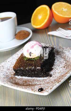 Platz saftige Schokolade Schwamm nass Kuchen mit Sauce im Formenbau und Kaffee Stockfoto