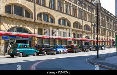 Taxis stehen aufgereiht außerhalb Victoria Bahnhof Manchester Stockfoto