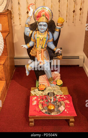 Eine Statue der hinduistischen Gottheit Kali, wo Käufer für wohltätige Zwecke spenden. In einem Geschäft auf der Liberty Avenue in South Richmond Hill, Queens, New York City. Stockfoto