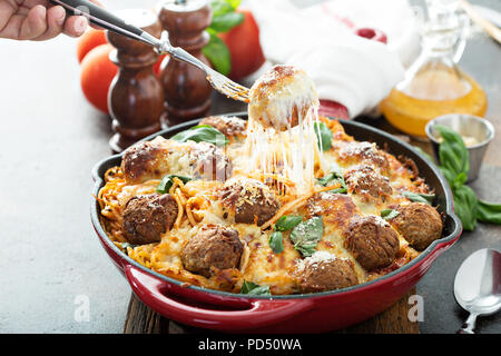 Gebackene Hackfleischbällchen mit Spaghetti, Tomatensauce, Basilikum und Käse mit Käse gezogen Stockfoto