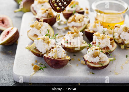 Herbst Vorspeisen, frische Feigen gefüllt mit Ricotta und Pinienkernen mit Honig und Thymian Stockfoto