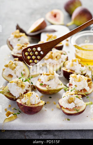 Herbst Vorspeisen, frische Feigen gefüllt mit Ricotta und Pinienkernen mit Honig und Thymian Stockfoto