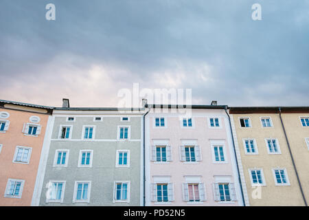 Bunte Häuser mit vielen Fenstern vor dem Hintergrund der untergehenden Sonne am Abend. Stockfoto