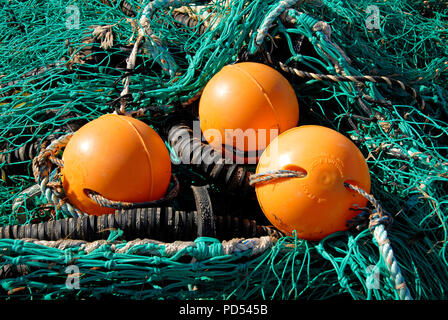 3 orange schwimmt und grünen Fischernetze, Norfolk, England Stockfoto