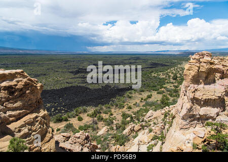 Blick auf die Lava Beds und Klippen unter stürmischen Himmel aus dem Sandstein Bluffs übersehen bei El Malpais National Monument in New Mexico Stockfoto