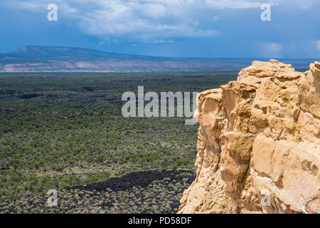 Blick auf die Lava Beds und Klippen unter stürmischen Himmel aus dem Sandstein Bluffs übersehen bei El Malpais National Monument in New Mexico Stockfoto