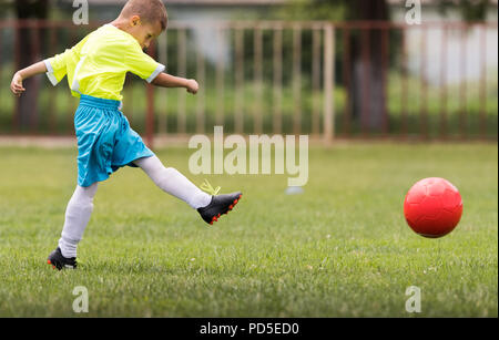 Junge kicken Fußball auf dem Sportplatz beim Fußballspiel Stockfoto