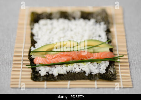 Rolling vorbereiten Maki shshi Rolle mit Lachs Stockfoto