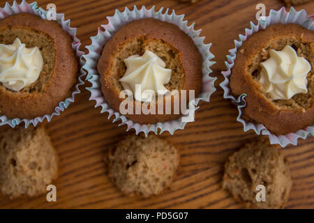 Mamas selbstgemachte Karotte Cupcakes mit Frischkäse füllen. Stockfoto