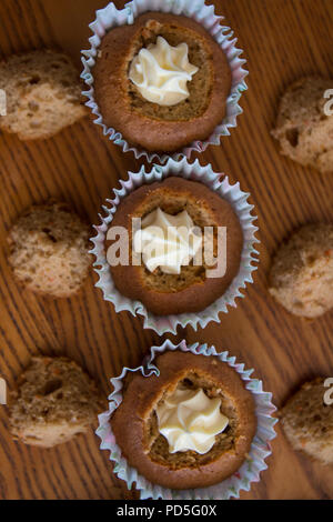 Mamas selbstgemachte Karotte Cupcakes mit Frischkäse füllen. Stockfoto