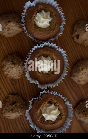 Mamas selbstgemachte Karotte Cupcakes mit Frischkäse füllen. Stockfoto