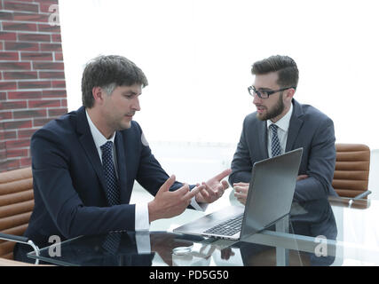 Zwei Geschäftsleute über Aufgaben im Büro sitzen. Stockfoto