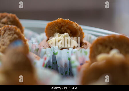 Mamas selbstgemachte Karotte Cupcakes mit Frischkäse füllen. Stockfoto
