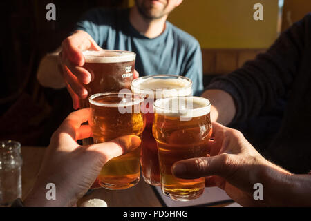 Eine Gruppe von vier klirren Gläser (2 Pints cask Ale und 2 halbe pints Apfelwein) und sagen Danke an die Black Bull Inn in Frosterley, County Durham, UK. Stockfoto