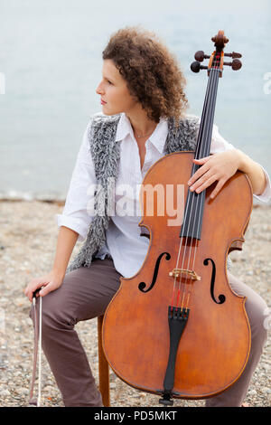 Frau spielt das Cello am Meer Stockfoto