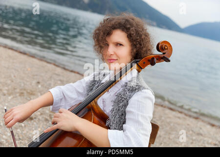 Frau spielt das Cello am Meer Stockfoto