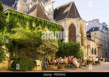 Café Paris Marais street scene - Menschen plaudern in einem Café in der Rue des Barres im Schatten der Kirche Saint Gervais in Frankreich Paris, Frankreich, Europa. Stockfoto