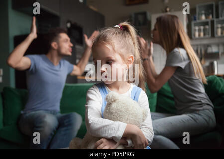 Kind Tochter Gefühl umgekippt, während die Eltern kämpfen im Hintergrund Stockfoto