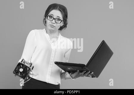 Portrait von sicher schön verwirrt junge geschäftsfrau mit Ausrüstung computer Teile in Schwarz und Weiß ratlos Stockfoto