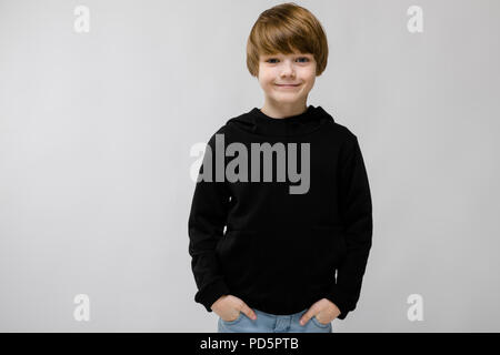 Portrait von adorable smilling kleiner Junge stehend im Studio auf grauem Hintergrund Stockfoto