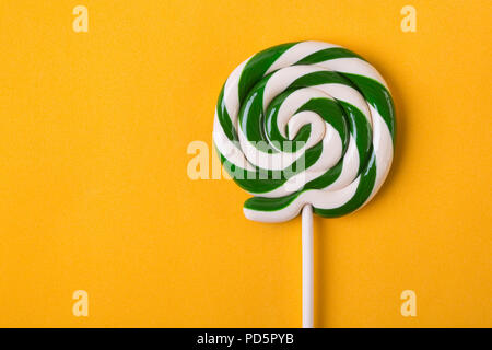 Ein twisted Lollipop auf gelbem Hintergrund Stockfoto