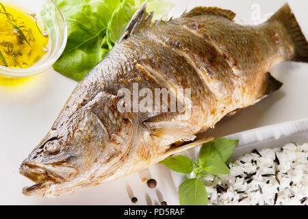 Fisch Baramundi Grill und wilder Reis auf weißem Hintergrund Stockfoto