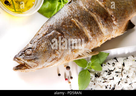 Fisch Baramundi Grill und wilder Reis auf weißem Hintergrund Stockfoto