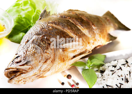 Fisch Baramundi Grill und wilder Reis auf weißem Hintergrund Stockfoto