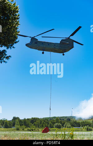 HENGELO, Niederlande - 1. Juli 2018: Die niederländischen Chinook Armee Hubschrauber erlischt ein großes Feuer an einem lokalen Abfall Verarbeitung Unternehmen während eines heißen Sommers Stockfoto