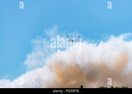 HENGELO, Niederlande - 1. Juli 2018: Die niederländischen Chinook Armee Hubschrauber erlischt ein großes Feuer an einem lokalen Abfall Verarbeitung Unternehmen während eines heißen Sommers Stockfoto