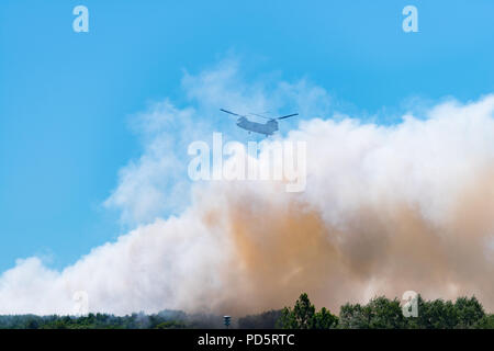 HENGELO, Niederlande - 1. Juli 2018: Die niederländischen Chinook Armee Hubschrauber erlischt ein großes Feuer an einem lokalen Abfall Verarbeitung Unternehmen während eines heißen Sommers Stockfoto