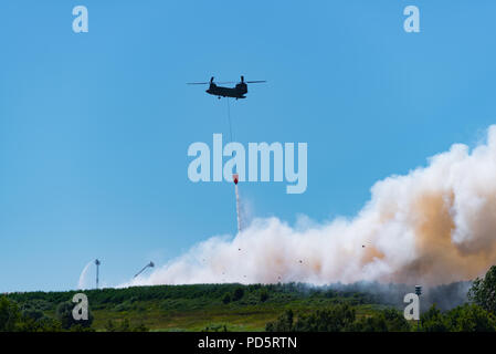 HENGELO, Niederlande - 1. Juli 2018: Die niederländischen Chinook Armee Hubschrauber erlischt ein großes Feuer an einem lokalen Abfall Verarbeitung Unternehmen während eines heißen Sommers Stockfoto