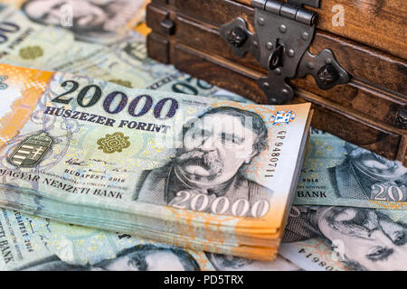 Stapel von Ungarischen 20000 Forint Banknoten mit einem Vintage Holzkiste. Konzept der Persönlichen Einsparungen und das Sammeln von Geld für den Ruhestand. Stockfoto