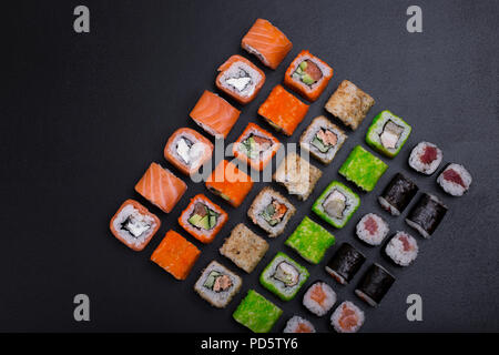 Japanisches sushi Rollen in der Form einer Linie auf schwarzem Hintergrund oben Stockfoto