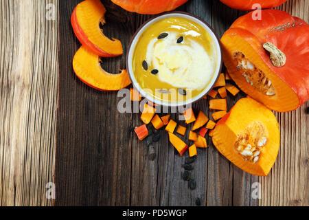 Gebratener Kürbis und Karotten Suppe mit Sahne und Kürbiskerne auf Tisch Stockfoto