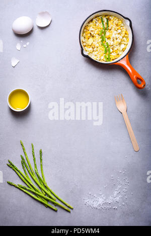 Warmes Frühstück, Spiegelei in einem kochenden Topf mit frischen Spargel. Flach, Ansicht von oben. Stockfoto