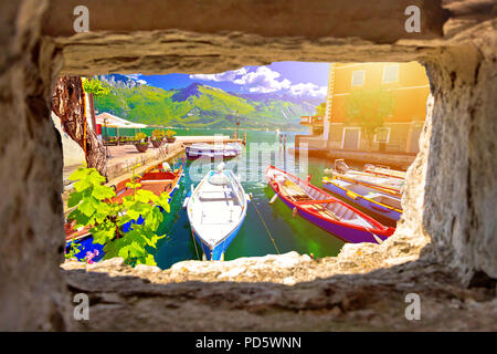 Limone sul Garda türkisfarbene Wasser und die Boote Blick durch Stein Fenster, Stadt in Lago di Garda, Lombardei, Italien Stockfoto