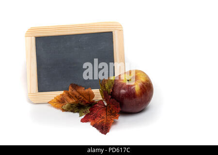 Leere Schiefertafel mit Apfel und Blätter im Herbst auf weißem Hintergrund Stockfoto